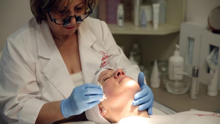 An aesthetician at Berenice giving a client a facial treatment